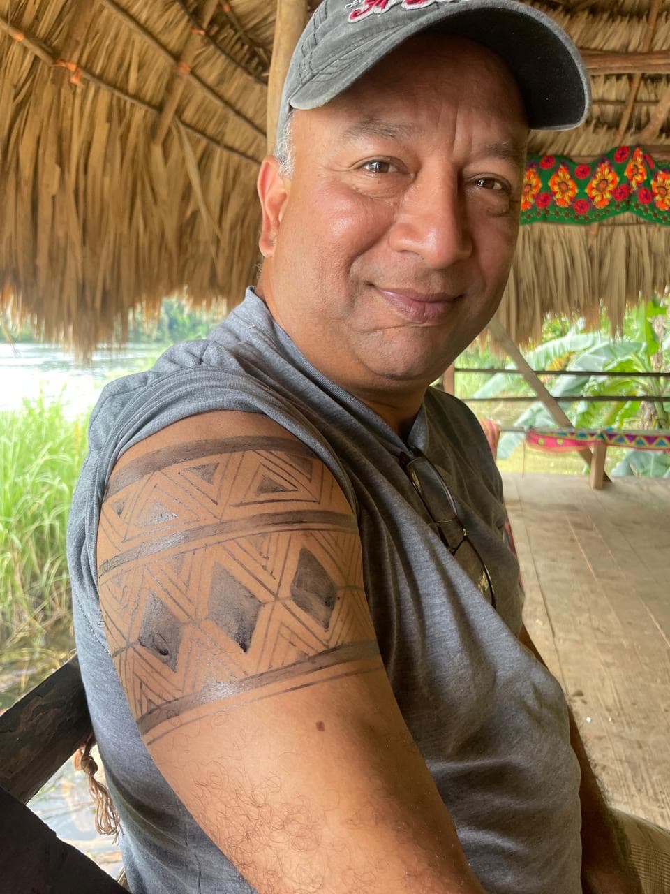 Benny con un tatuaje Emberá de tinta vegetal en el brazo, en una casa comunitaria junto al río